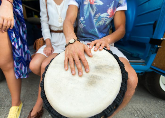close up of hippie friends playing tom-tom drum