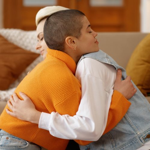 Young lesbian woman couple supporting each other, reconciling after quarrel